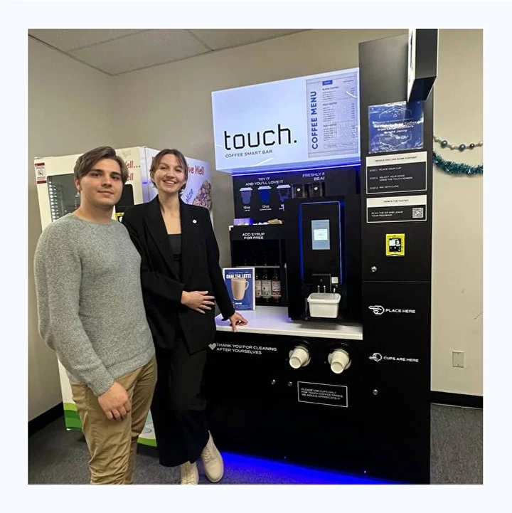 Two people standing beside our Touch Coffee smart bar.